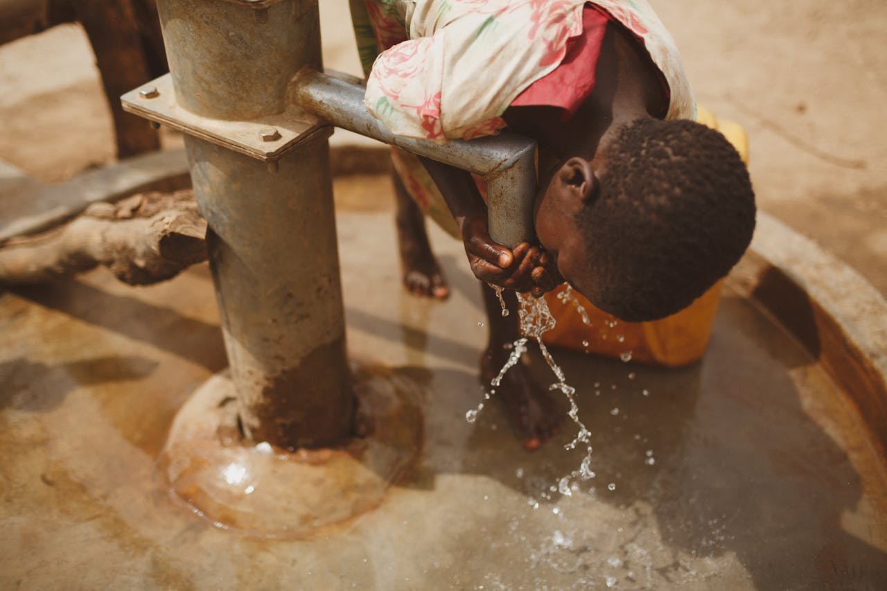 Girl Drinking Water from the Pipe